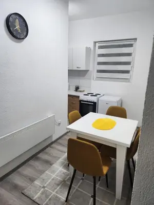 a small kitchen with a white table and chairs at Apartmani Una Lux in Spilja