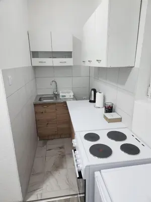 a white kitchen with a stove and a sink at Apartmani Una Lux in Spilja
