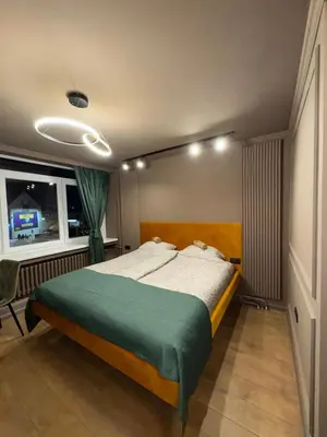 a bedroom with a large bed with a green blanket at Apartman Iris in Banja Luka