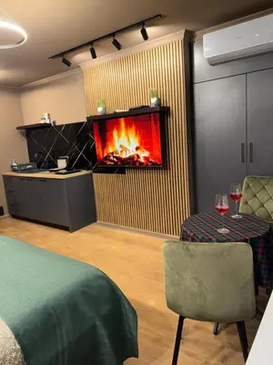 a living room with a fireplace in the wall at Apartman Iris in Banja Luka
