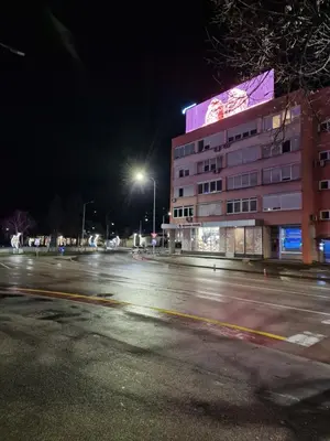 an empty street at night with a building at Apartman Iris in Banja Luka