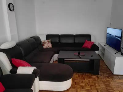 a living room with a black couch and a table at Empress in Banja Luka