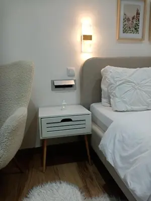 a bedroom with a bed and a nightstand with a white bed at Sava & Room in Prijedor