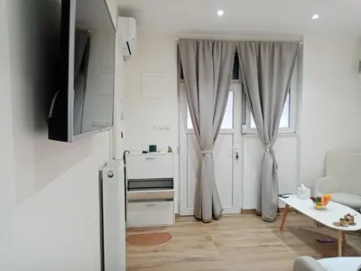 a small white kitchen with a window and a table at Sava & Room in Prijedor
