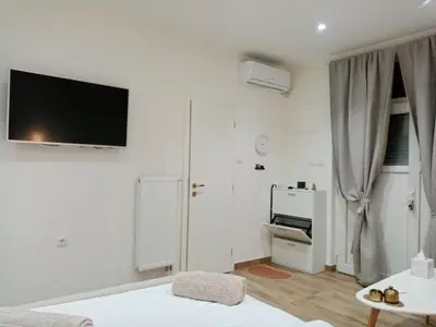 a white room with a bed and a tv on the wall at Sava & Room in Prijedor
