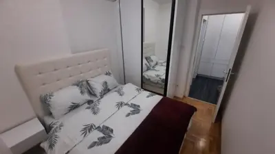 a bedroom with a bed and a mirror at Zlatni San apartman 2 in Banja Luka