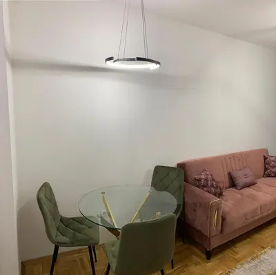 a living room with a glass table and a couch at Zlatni San apartman 2 in Banja Luka