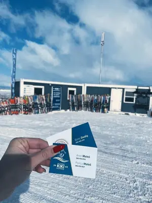a person holding a card in front of a ski lodge at Apartman KIKI in Kupres