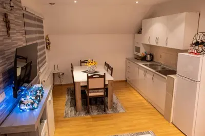 a kitchen with a table and a white refrigerator at Apartman KIKI in Kupres