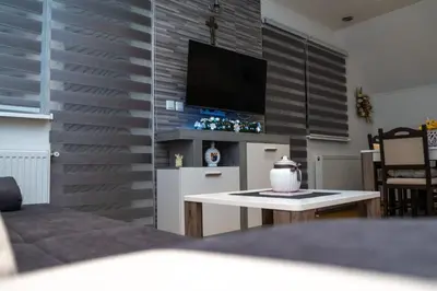 a living room with a tv on a wall at Apartman KIKI in Kupres