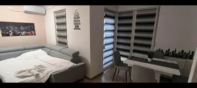 a bedroom with a couch and a desk and a table and a tableablish at City apartman Modrica in Modriča