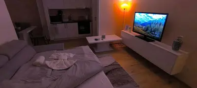 a living room with a couch and a flat screen tv at City apartman Modrica in Modriča