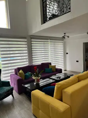 a living room with a purple couch and a table at Villa Uno Momento in Sreće