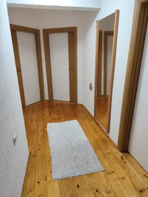 an empty room with a white rug on a wooden floor at Kuća za odmor Kukavičko jezero in Kupres