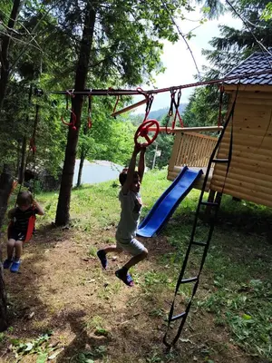 a young boy is playing on a playground at Kuća za odmor Kukavičko jezero in Kupres