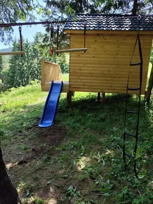 a playground with a blue slide and a house at Kuća za odmor Kukavičko jezero in Kupres
