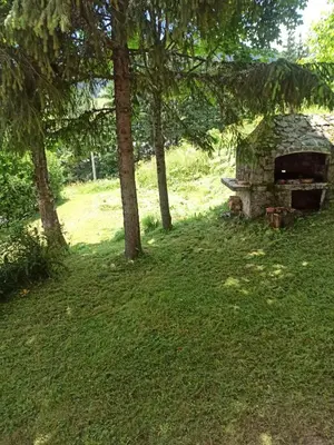 a stone oven in a field with trees at Kuća za odmor Kukavičko jezero in Kupres
