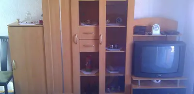 a wooden book shelf with a television in a room at Apartman Kupres u centru grada in Kupres