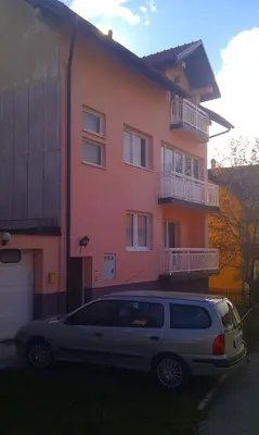 a silver van parked in front of a house at Apartman Kupres u centru grada in Kupres