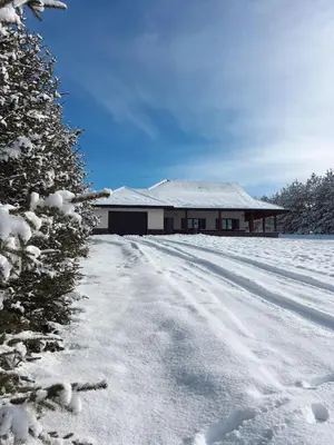 a snow covered road leading to a house at Planinska kuća Ema in Kupres
