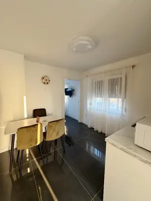 a kitchen and dining room with a table and chairs at Kastel Apartmani in Banja Luka