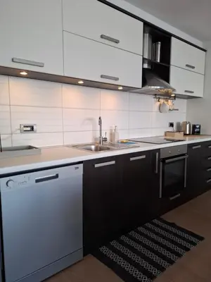a kitchen with white cabinets and a sink and a dishwasher at Apartman MAX sa privatnim parkingom in Banja Luka
