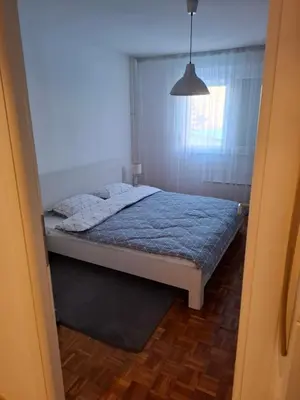 a bedroom with a bed with a blue comforter at Apartman MAX sa privatnim parkingom in Banja Luka