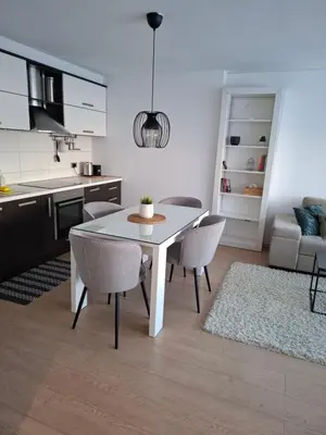 a kitchen and dining room with a white table and chairs at Apartman MAX sa privatnim parkingom in Banja Luka