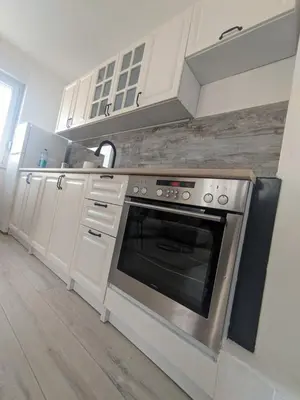 a kitchen with a stainless steel oven and white cabinets at Apartman Isak in Banja Luka