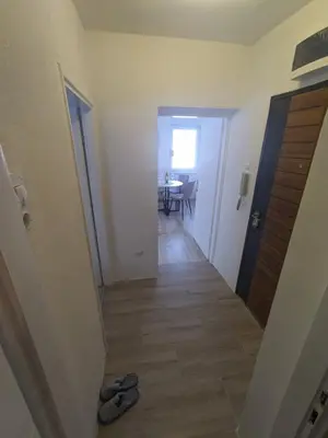 a hallway with a door and a room with a table at Apartman Isak in Banja Luka