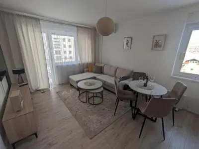 a living room with a couch and a table and chairs at Apartman Isak in Banja Luka