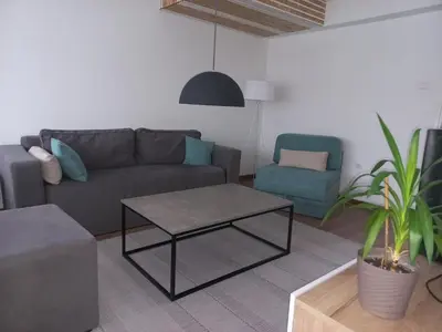 a living room with a couch and a table and a chair at Apartman Mina in Banja Luka