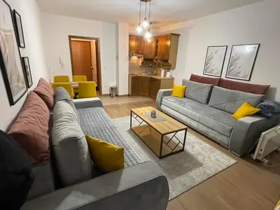 a living room with a gray couch and yellow pillows at Apartman Vlašić Eko Fis 508 in Šišava