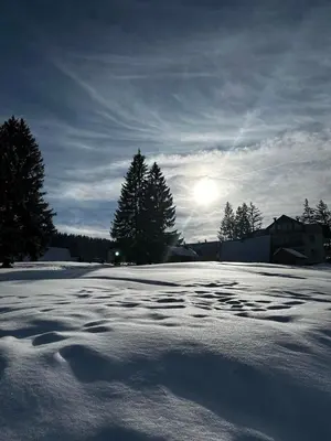 a snow covered parking lot with the sun in the background at Apartman Kovačević Vlašić in Vlasic