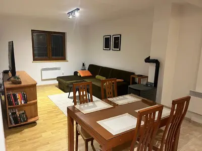 a living room with a table and a couch at Kupres Apartman555 in Kupres