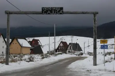 a street sign over a road in a snow covered village at Kupres Apartman555 in Kupres