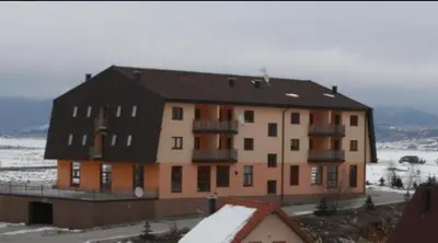 a large apartment building with snow on the ground at Kupres Apartman555 in Kupres