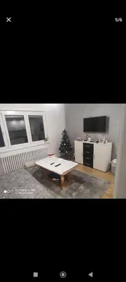 a living room with a table and a christmas tree at Silvestar-Home house in Zenica