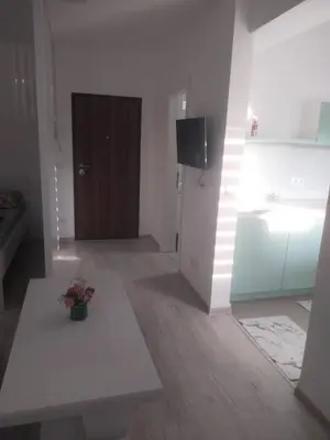 a living room with a table and a door at Stan na dan in Žepče