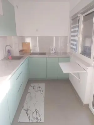 a white kitchen with a sink and a window at Stan na dan in Žepče