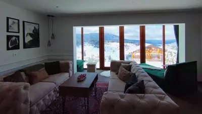 a living room with couches and a large window at Pine Apartment in Travnik