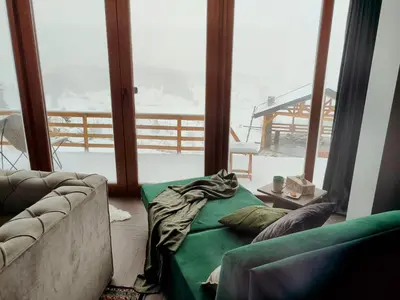 a living room with a couch and a large window at Pine Apartment in Travnik