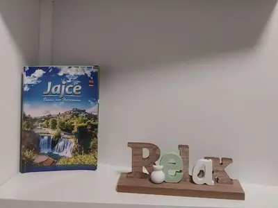 a book and a sign on a wall next to a table at Apartman Paradiso in Jajce