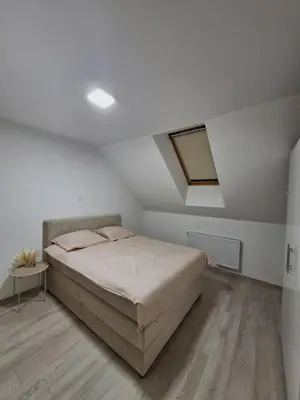 a white bedroom with a bed and a skylight at Apartman REINA HOME in Prijedor