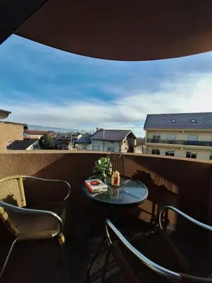 a table and chairs on a balcony with a view at Apartman REINA HOME in Prijedor