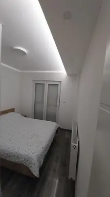 a small bedroom with a bed and a ceiling at Luka Opal in Doboj