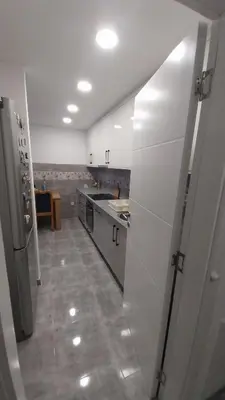 a large kitchen with white cabinets and a tile floor at Luka Opal in Doboj