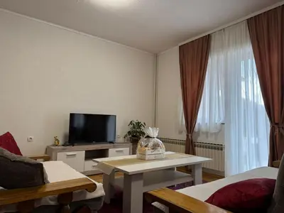 a living room with a tv and a table at APARTMAN Iva in Tomislavgrad