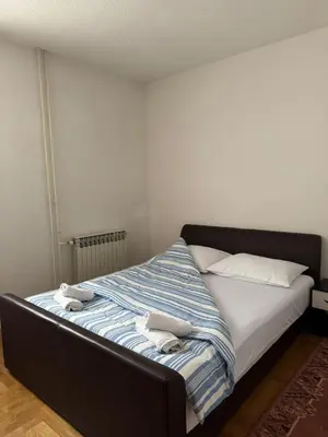 a bed in a room with two towels on it at APARTMAN Iva in Tomislavgrad
