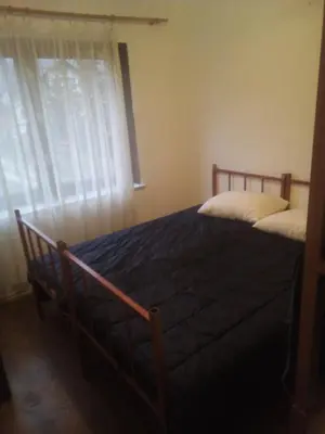 a bedroom with a bed and a window with curtains at apartman SM IK 5 in Šujica
